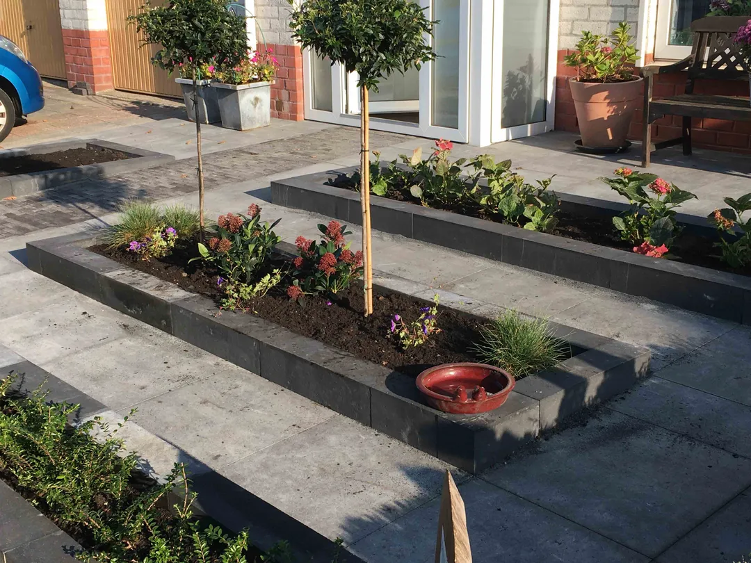 Voortuin met verhoogde plantenbakken en bestrating